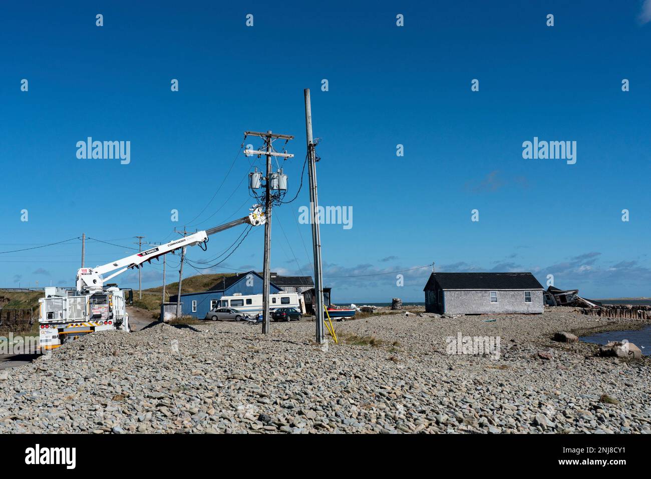 Workers tend to electrical poles at la Grave near damaged cottages on