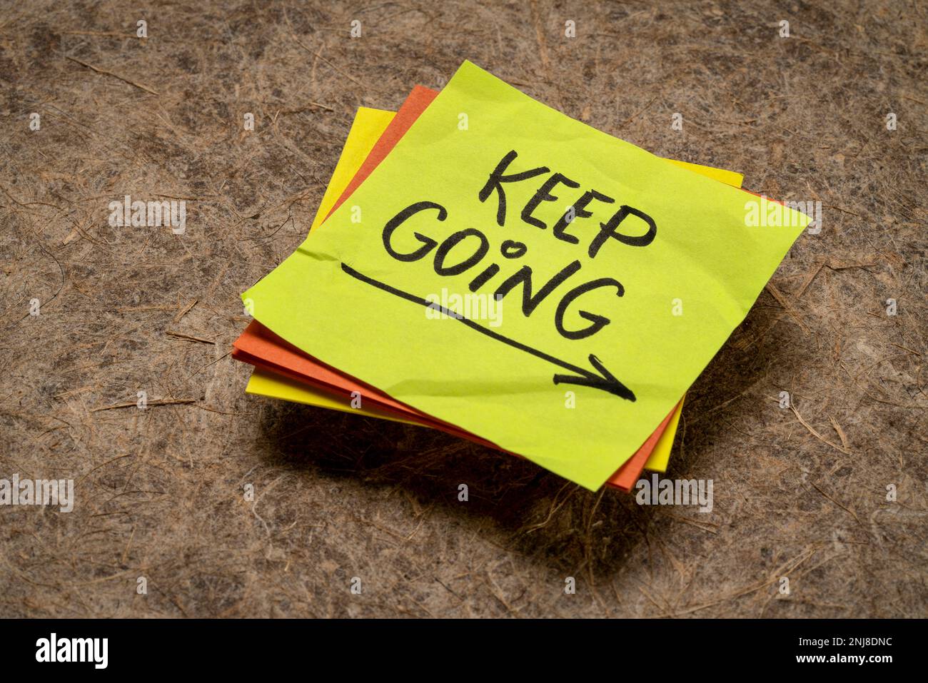 keep going - motivation or determination concept - handwriting on a sticky note Stock Photo