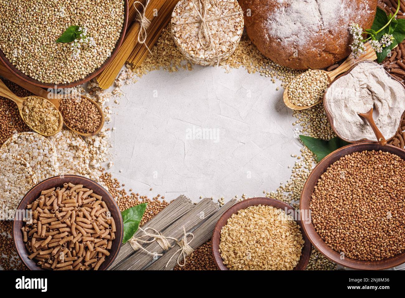 Rural still-life, top view - the peeled groats of buckwheat (Fagopyrum esculentum) and products made from it, as background, closeup Stock Photo
