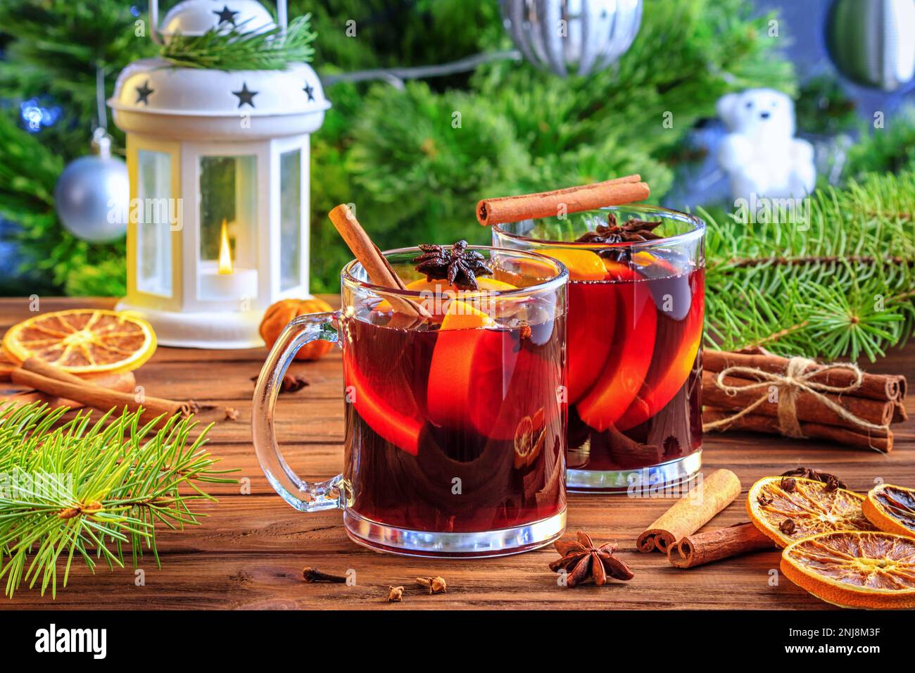 Christmas mulled red wine glühwine with aromatic spices and citrus fruits on a wooden rustic table, close-up. Traditional hot drink or festive cocktai Stock Photo