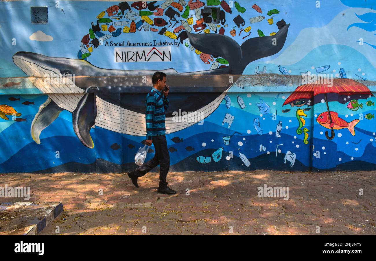 West Bengal, India. 21st Feb, 2023. A man walks past a mural depicting