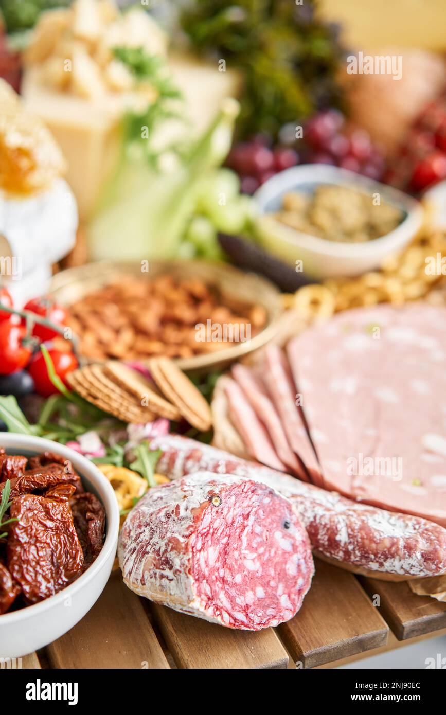 Salami sausage close-up. Table full of mediterranean appetizers, tapas ...