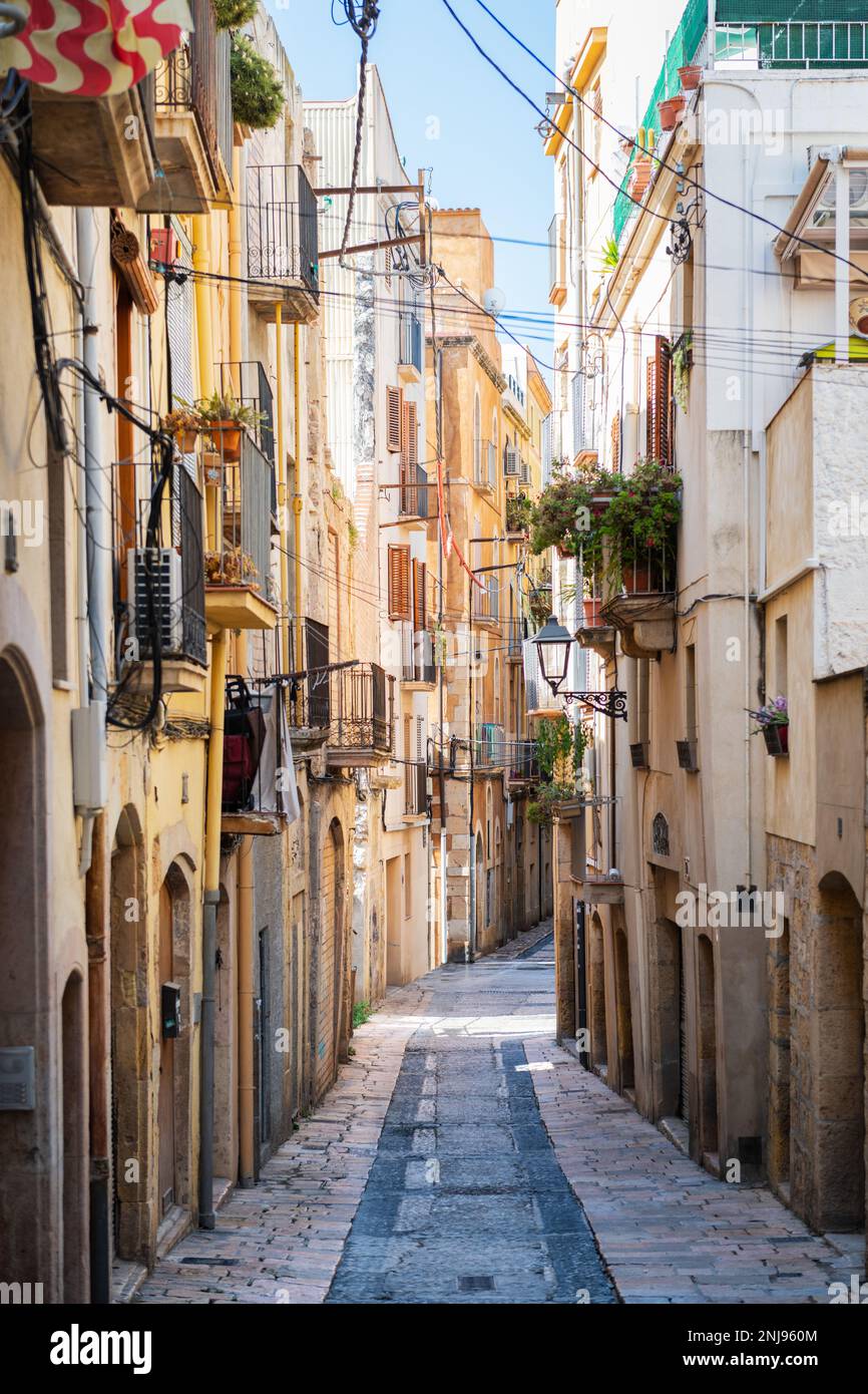 Empty narrow street in the old town of Tarragona, a tourist port city by the Mediterranean Sea in the northeast of Spain. Stock Photo