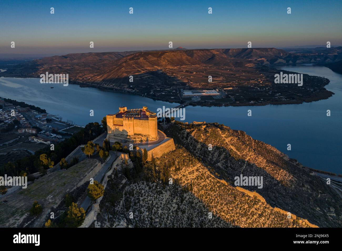Aerial view of the castle of Mequinenza at the confluence of the Segre and Ebro rivers in a winter sunset (Bajo Cinca, Zaragoza, Aragon, Spain) Stock Photo