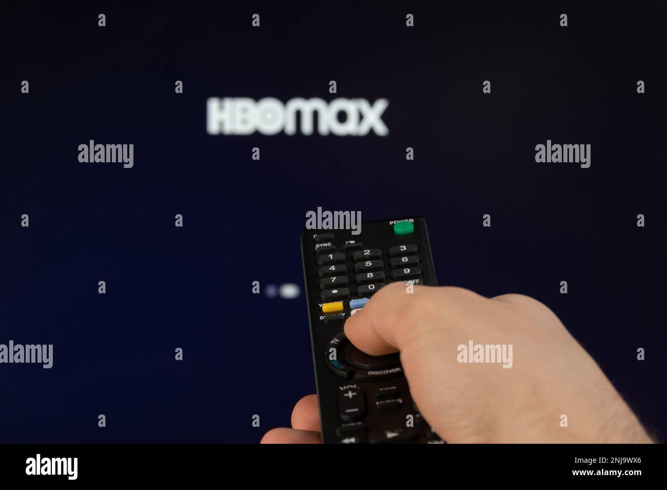 New york, USA - February 21, 2023: Play HBOMAX streaming platform on tv with remote control in hand Stock Photo