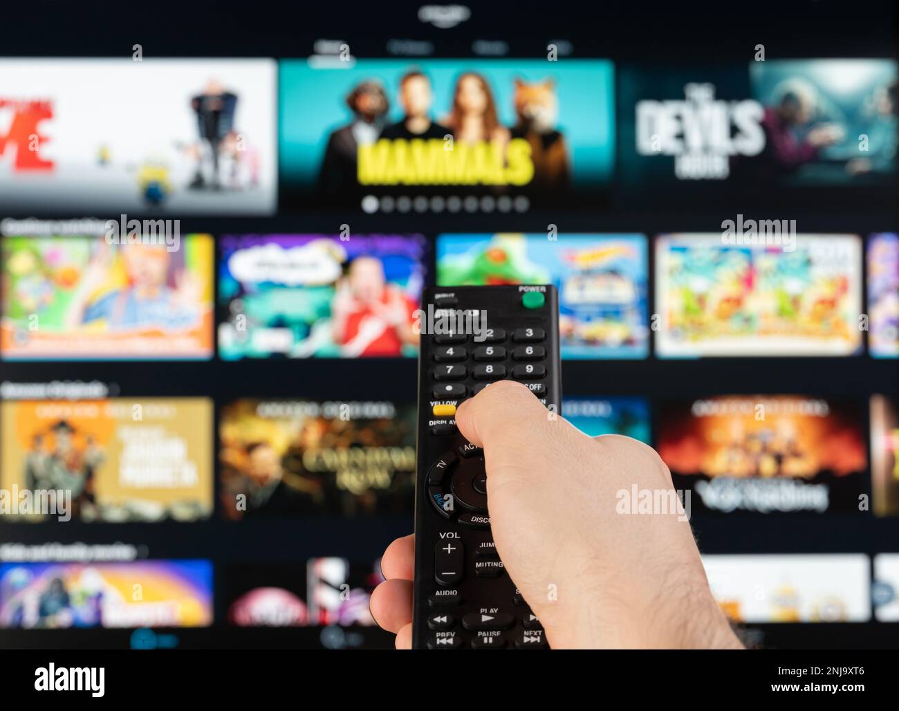 New york, USA - February 21, 2023: Select video on Amazon prime platform stream service on tv with remote control in hand Stock Photo