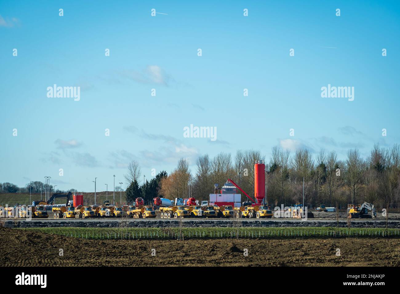 Multiple cars, excavators, trucks, loaders, concrete mixers and