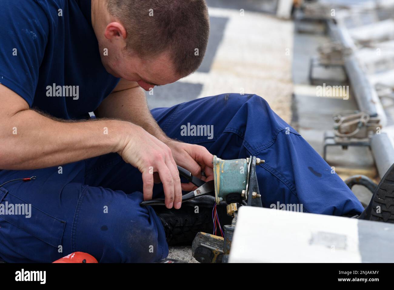 U.S. Coast Guard Petty Officer 2nd Class Jordan Reynolds conducts maintenance on an outlet aboard the Famous-class medium endurance cutter USCGC Mohawk (WMEC 913) while underway in the Atlantic Ocean, Aug. 6, 2022. USCGC Mohawk is on a scheduled deployment in the U.S. Naval Forces Africa area of operations, employed by U.S. Sixth Fleet to defend U.S., allied, and partner interests. Stock Photo