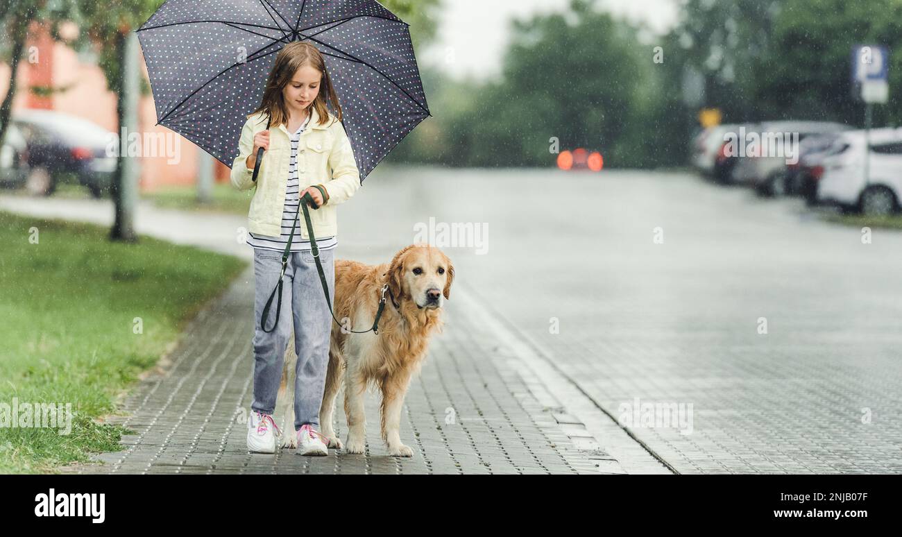 Girl with golden retriever dog in rainy day Stock Photo - Alamy