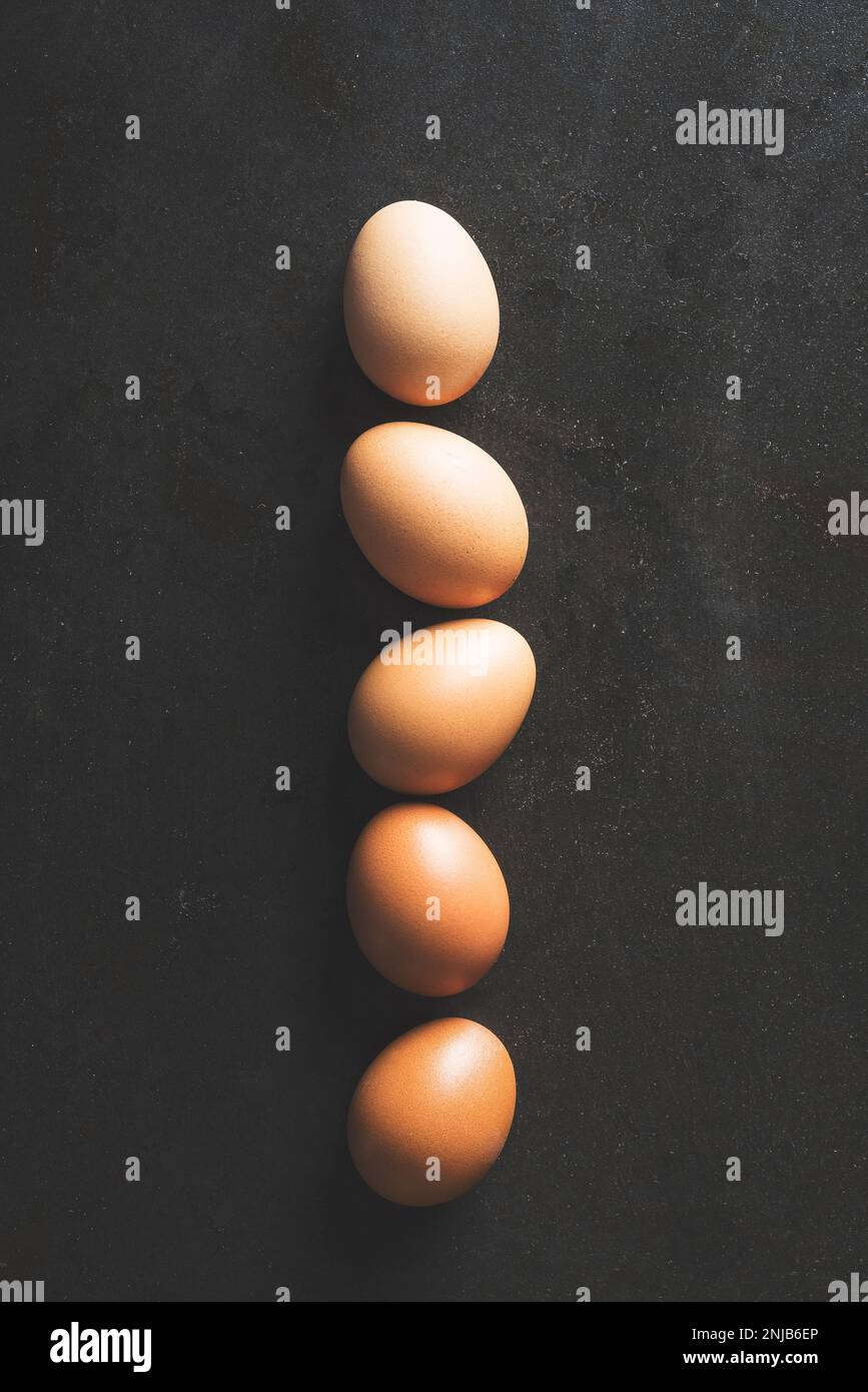 Color gradient eggs lined up in a row on black background Stock Photo