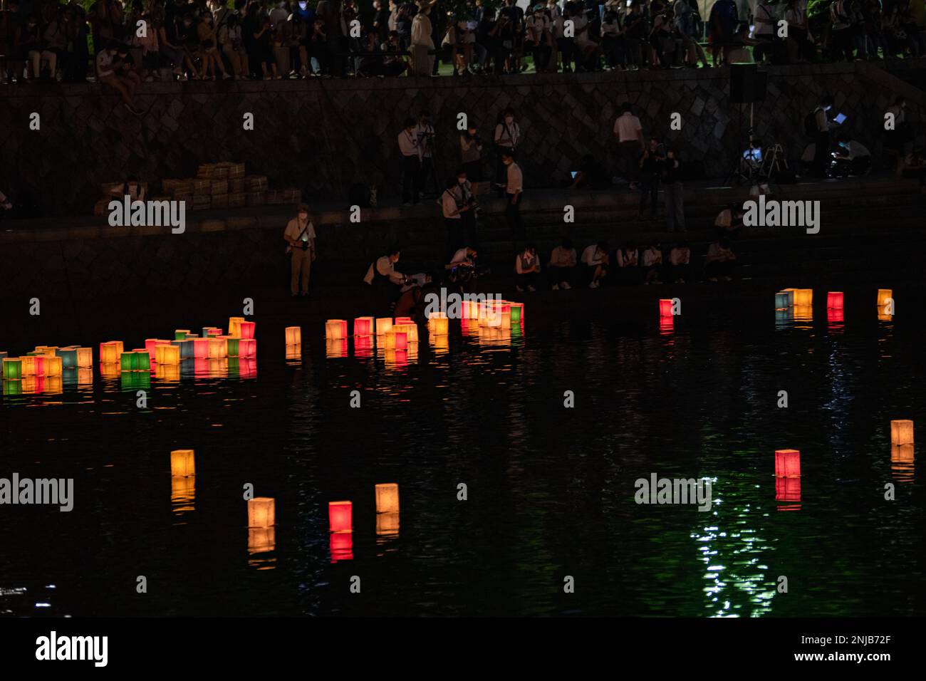 Japanese residents place lanterns on the Motoyasu River during the Peace Message Lantern Floating Ceremony in Hiroshima, Japan, Aug. 6, 2022. The event is held annually to honor those lost to the atomic bombing of Aug. 6, 1945, and to promote peace among nations. Stock Photo