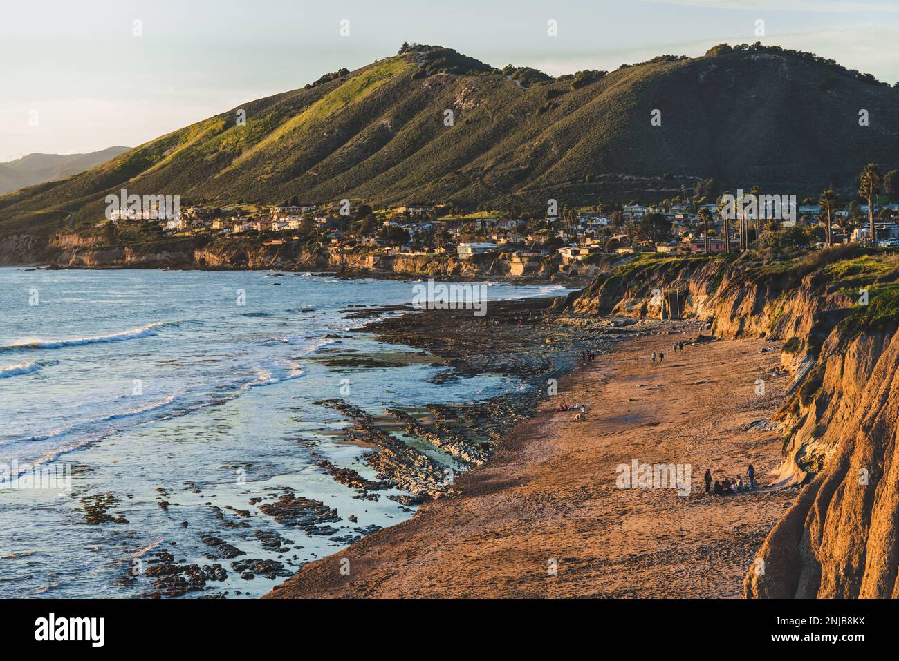 Pismo beach cliffs, wide sandy beach at low tide, green hills, and