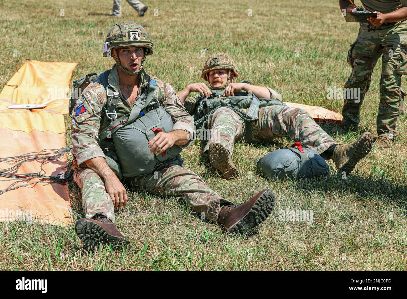 Two British paratroopers prepare to collect their chutes after making it to the x one after the