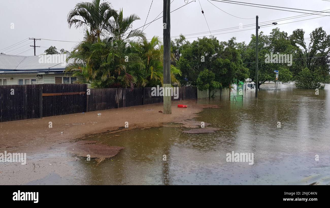 Brisbane, Australia - Feb 27, 2022: Road and house flooded after the heavy rain in Rocklea suburb, vehicle under water. Stock Photo