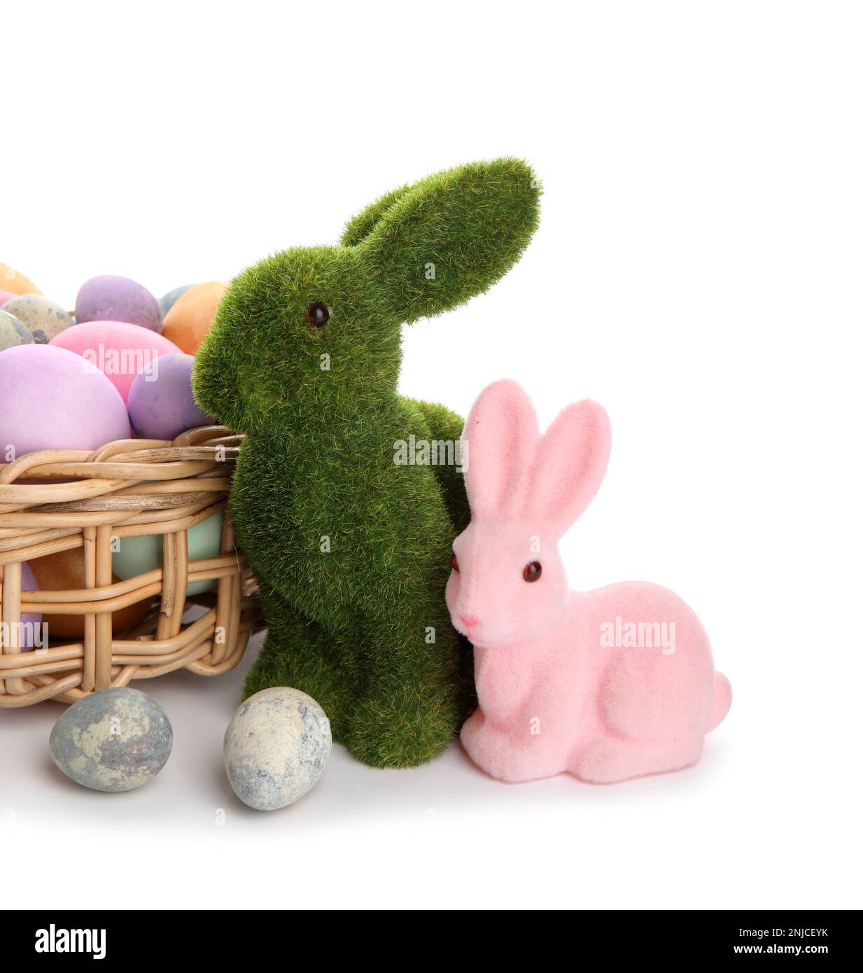 Easter bunnies and wicker basket with painted eggs isolated on white ...