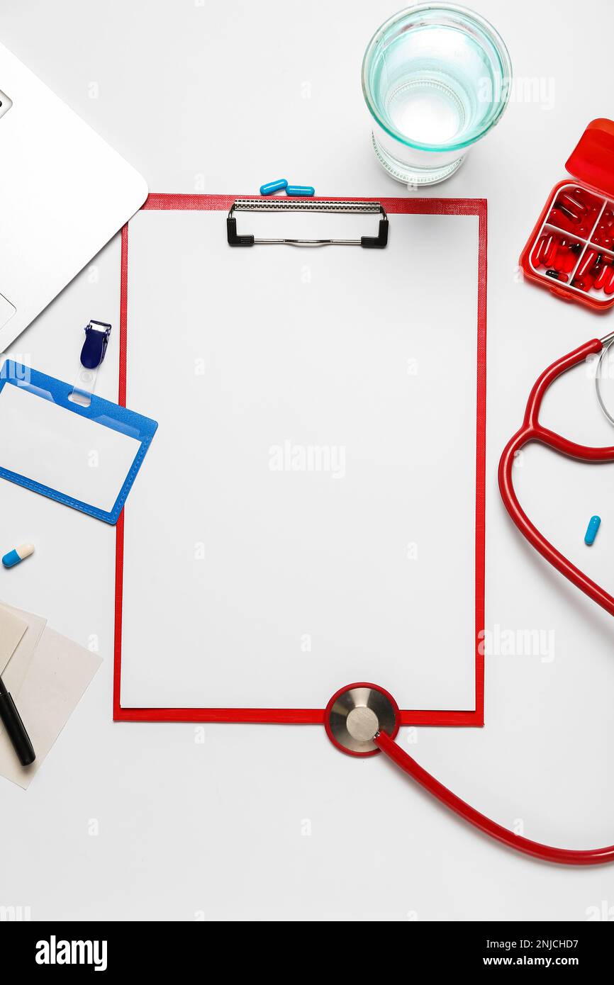 Blank clipboard with badge and medical supplies on white background