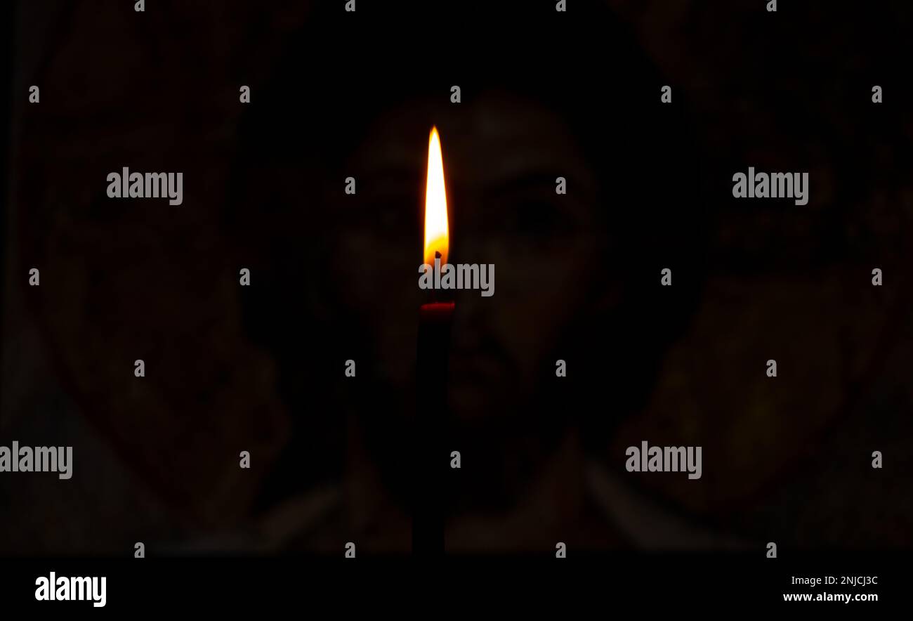 burning candle illuminates the icon of Jesus Christ Stock Photo Alamy