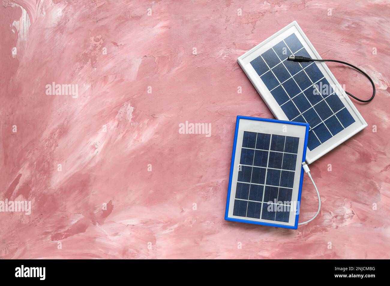 Portable solar panels with cables on pink grunge background Stock Photo ...