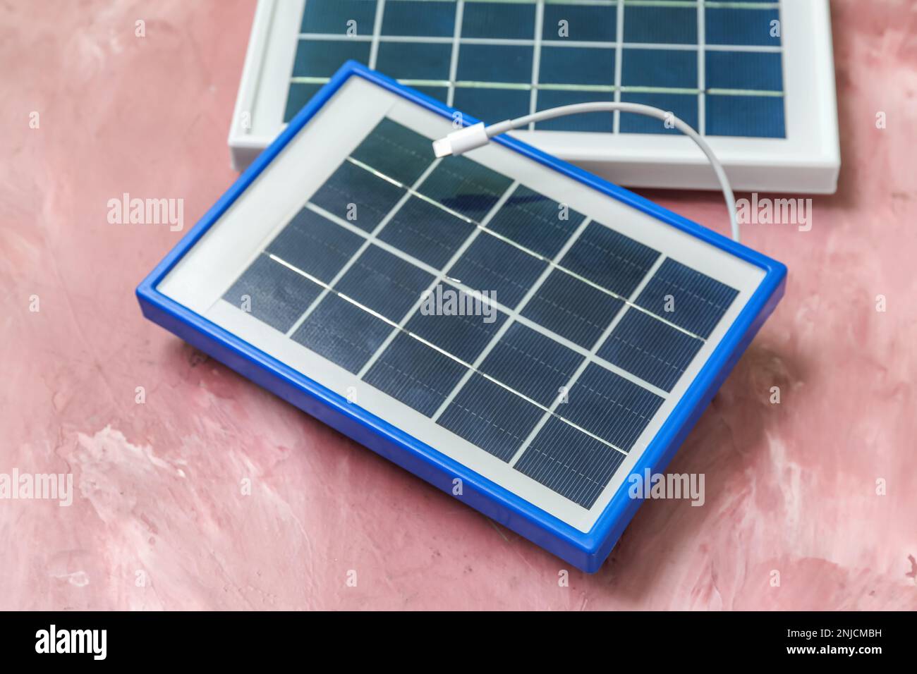 Portable solar panels with cable on pink grunge background Stock Photo ...