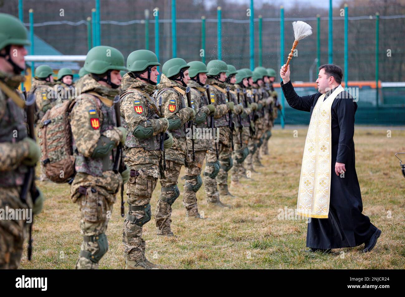 LVIV REGION, UKRAINE - FEBRUARY 22, 2023 - A priest sprinkles holy water during the graduation ceremony of the officers of the Armed Forces of Ukraine Stock Photo