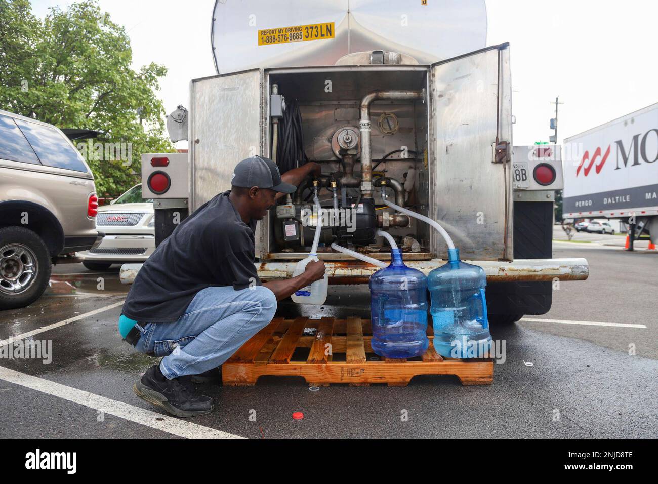 Shavarus Stamper fills jugs with water across from the Summerville Fire