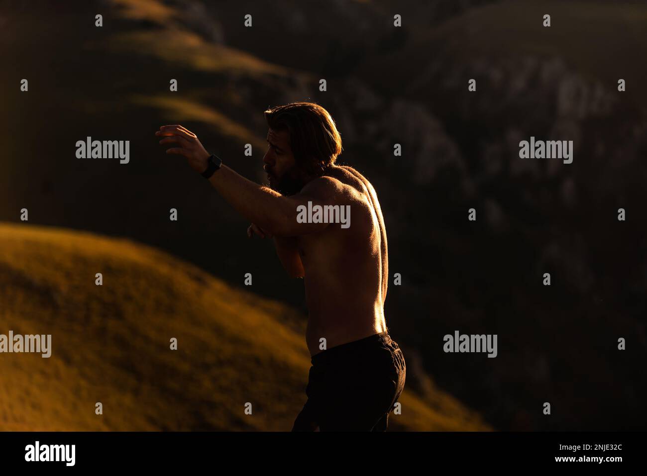 Man boxing with shadow exercising at sunset outdoor. Port victory