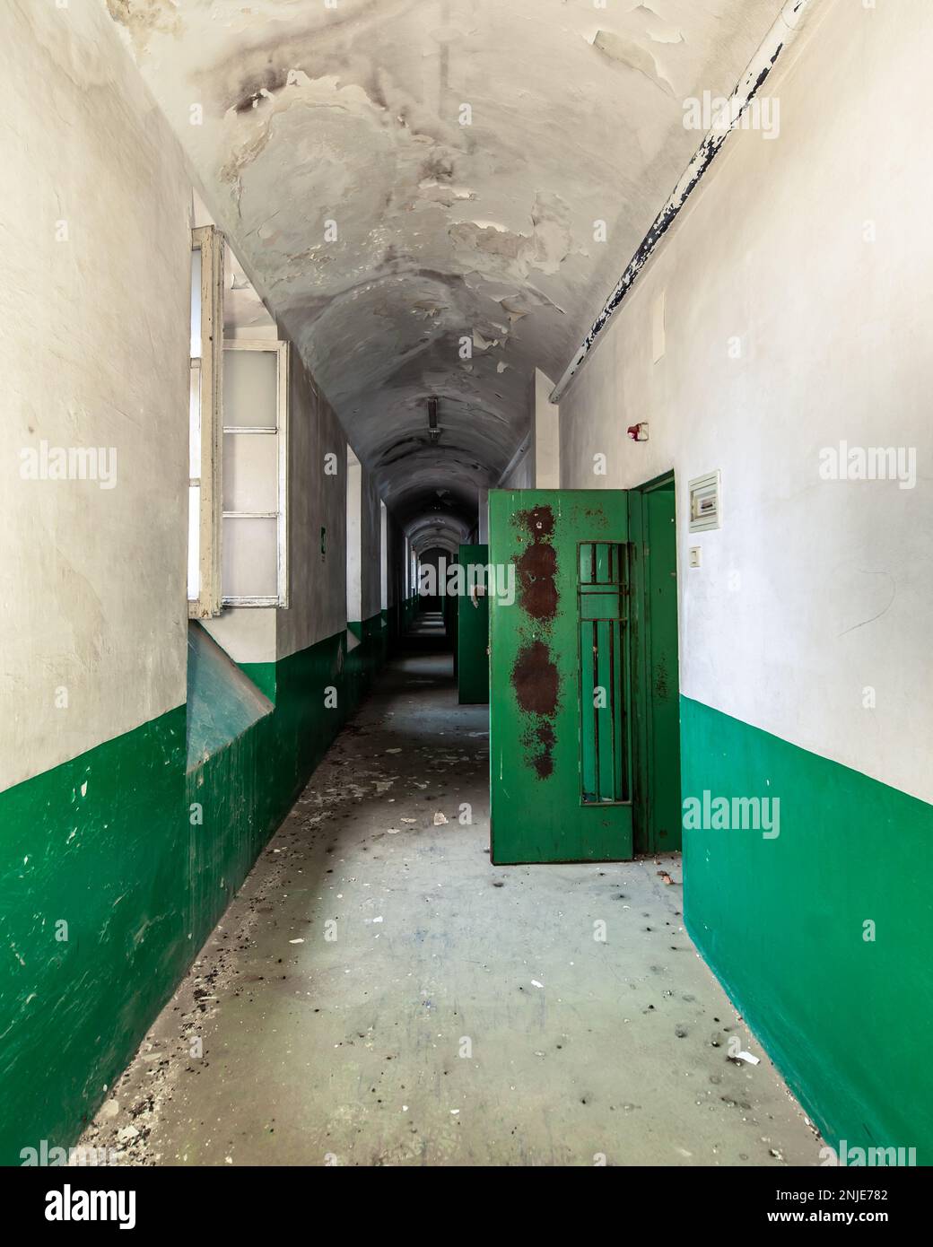 corridor of an abandoned prison, door cell are open, rusty and decay ...