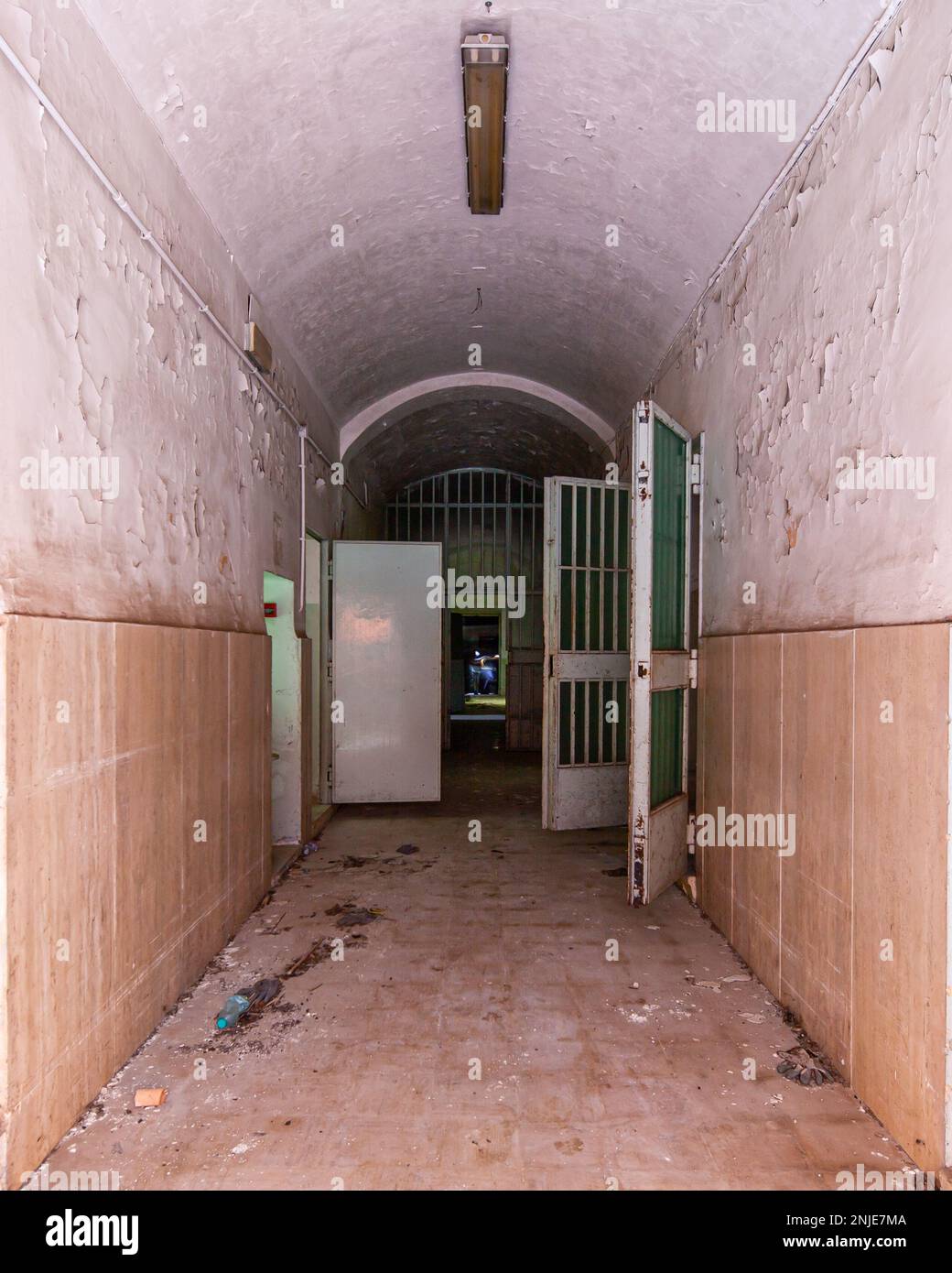 corridor of an abandoned prison, door cell are open, rusty and decay ...
