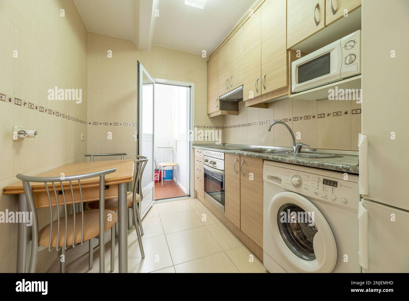 kitchen with birch wood furniture with metal handles, a stone-like  countertop with integrated electromessives of various colors, yellow tiles  and a co Stock Photo - Alamy, image size:1300x957