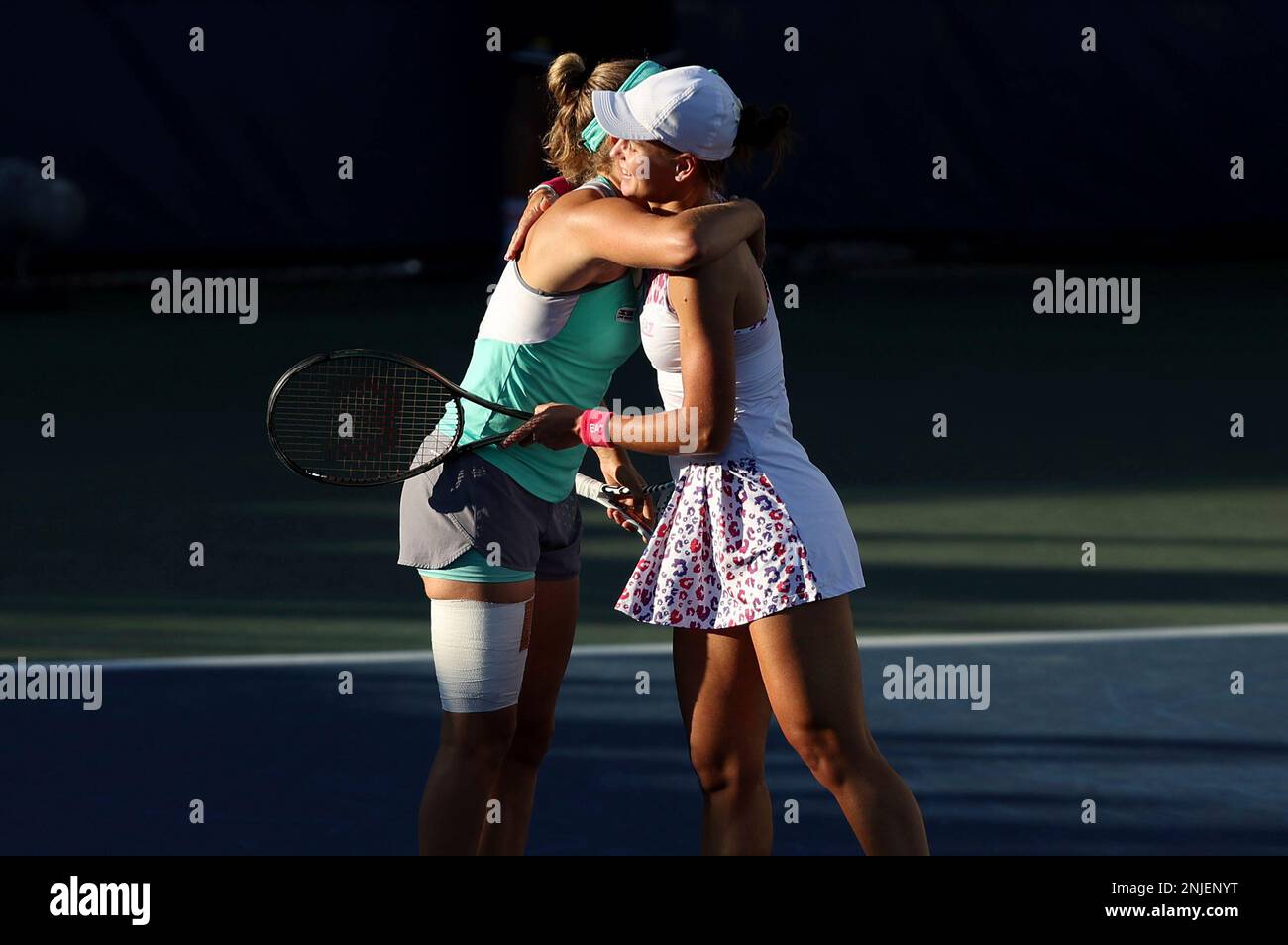 Elise Mertens and Veronika Kudermetova react after winning a women's