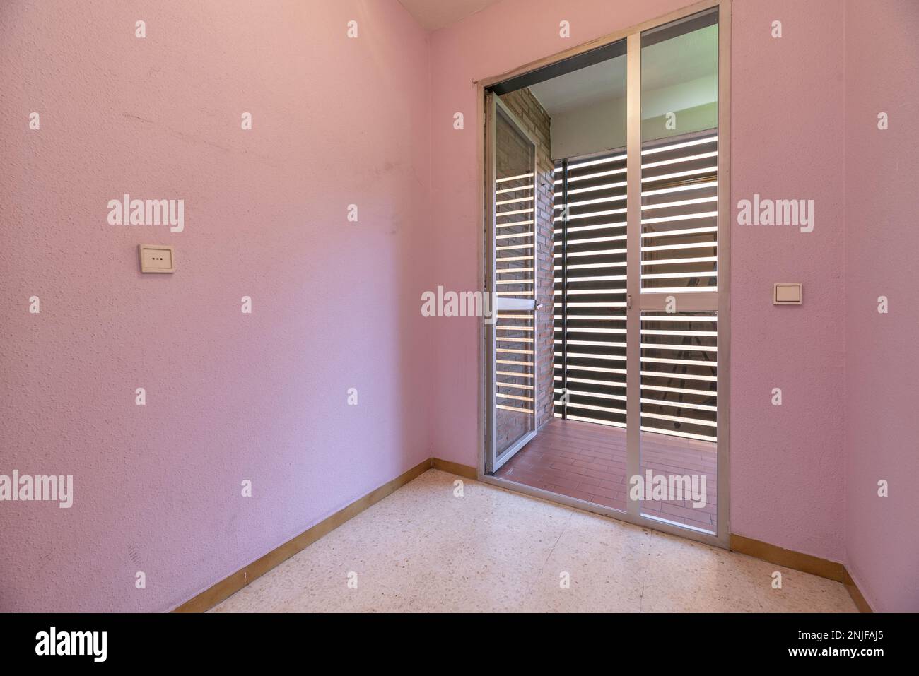 Empty bedroom with pink walls, and exit to a clothesline terrace with ...