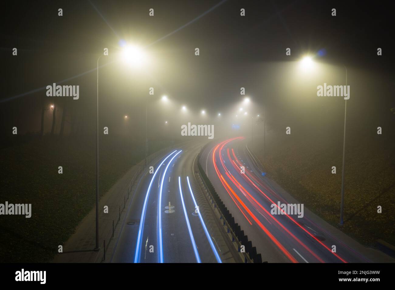 Fog over the night road, trail of light Stock Photo
