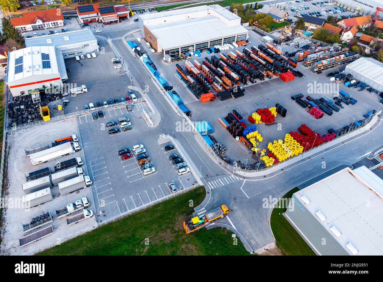 Drone shot of an industrial lot with some trucks, warehouses, a factory, and grain silos Stock Photo