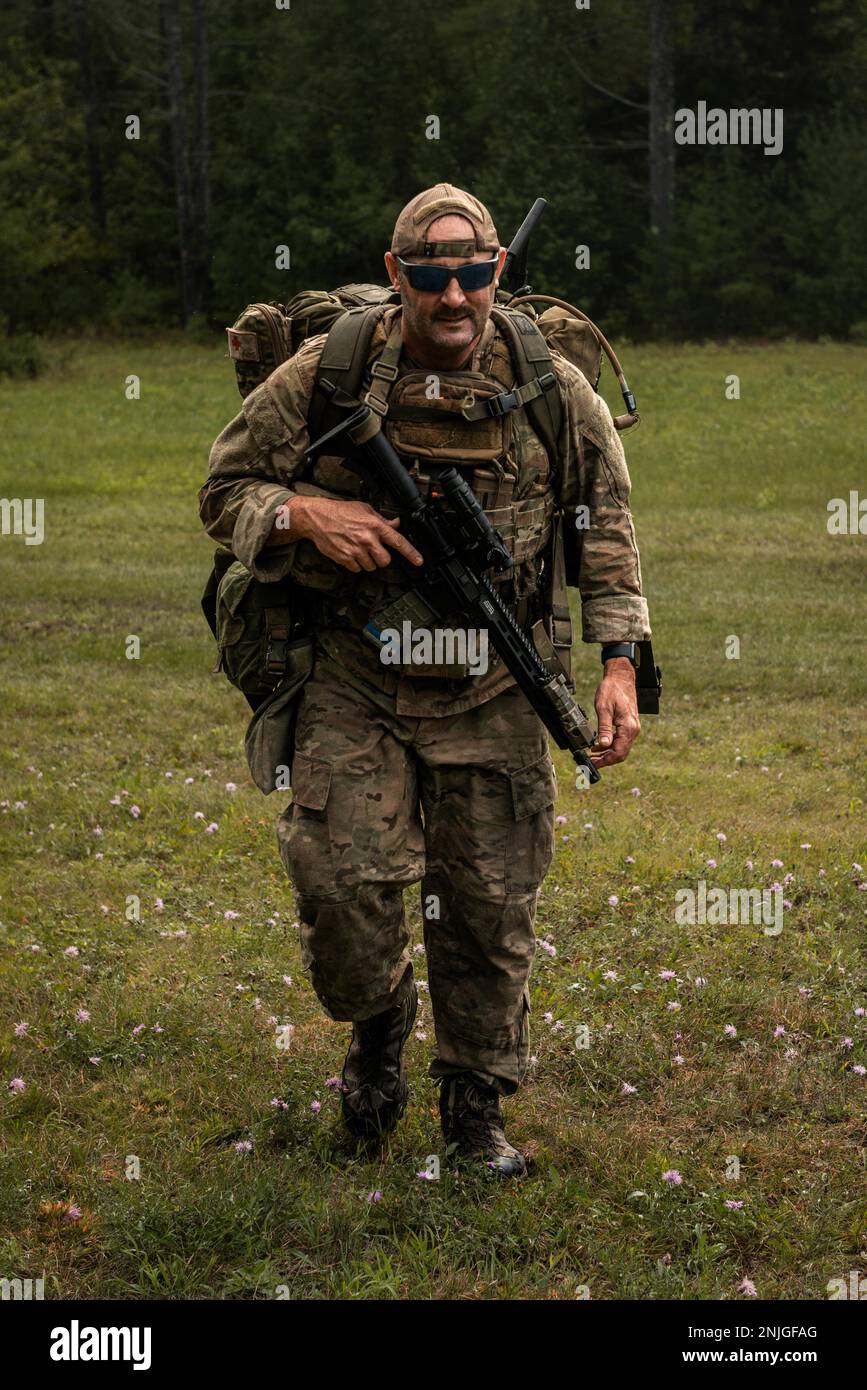 An airman assigned to the New York Air National Guard’s 274th Air Support Operations Squadron based in Syracuse, part of the 107th Attack Wing, hikes to a designated landing zone during a tactical air control party training procedure in Upstate N.Y., Aug. 6, 2022. The training was a part of an operation run by the Air Force Research Lab to test experimental technology and its uses in tactical situations. Stock Photo