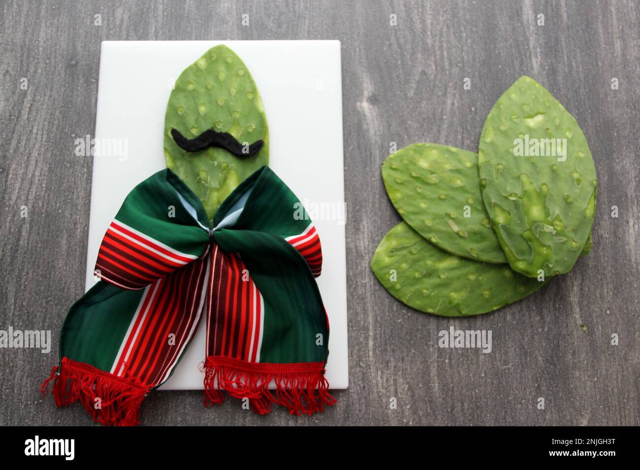Nopal face with mustache and bow tie festive mexican style on wooden table and cutting board ready for mexican party Stock Photo