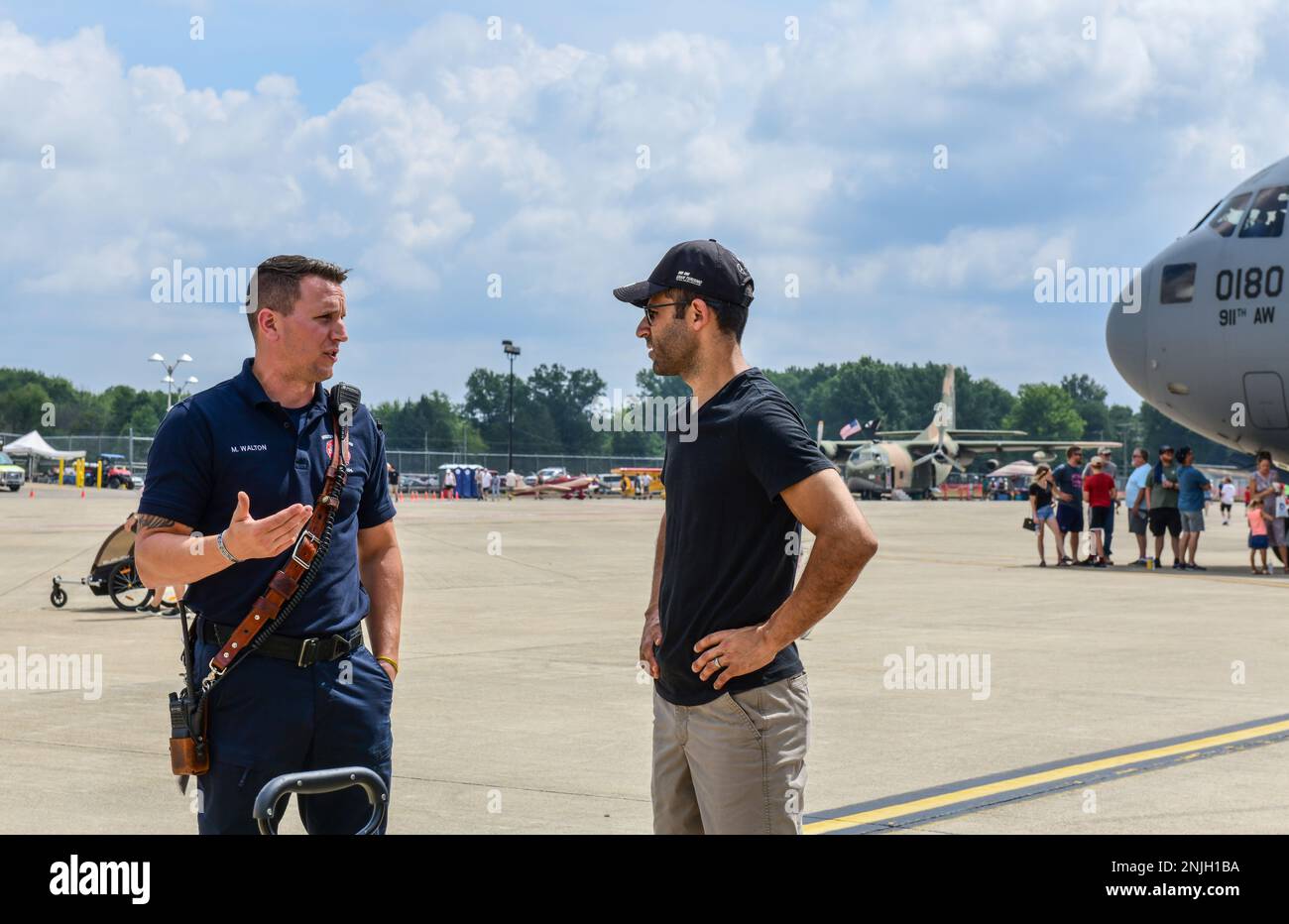 Mike Walton, a firefighter with Youngstown Air Reserve Station’s fire department, talks with an event guest on the flightline, Aug. 7, 2022, at the Wings and Wheels Fly-In and Car Show at Youngstown-Warren Regional Airport, Ohio. The event had more than 100 different aircraft on display with some available for event guests to tour inside. Stock Photo