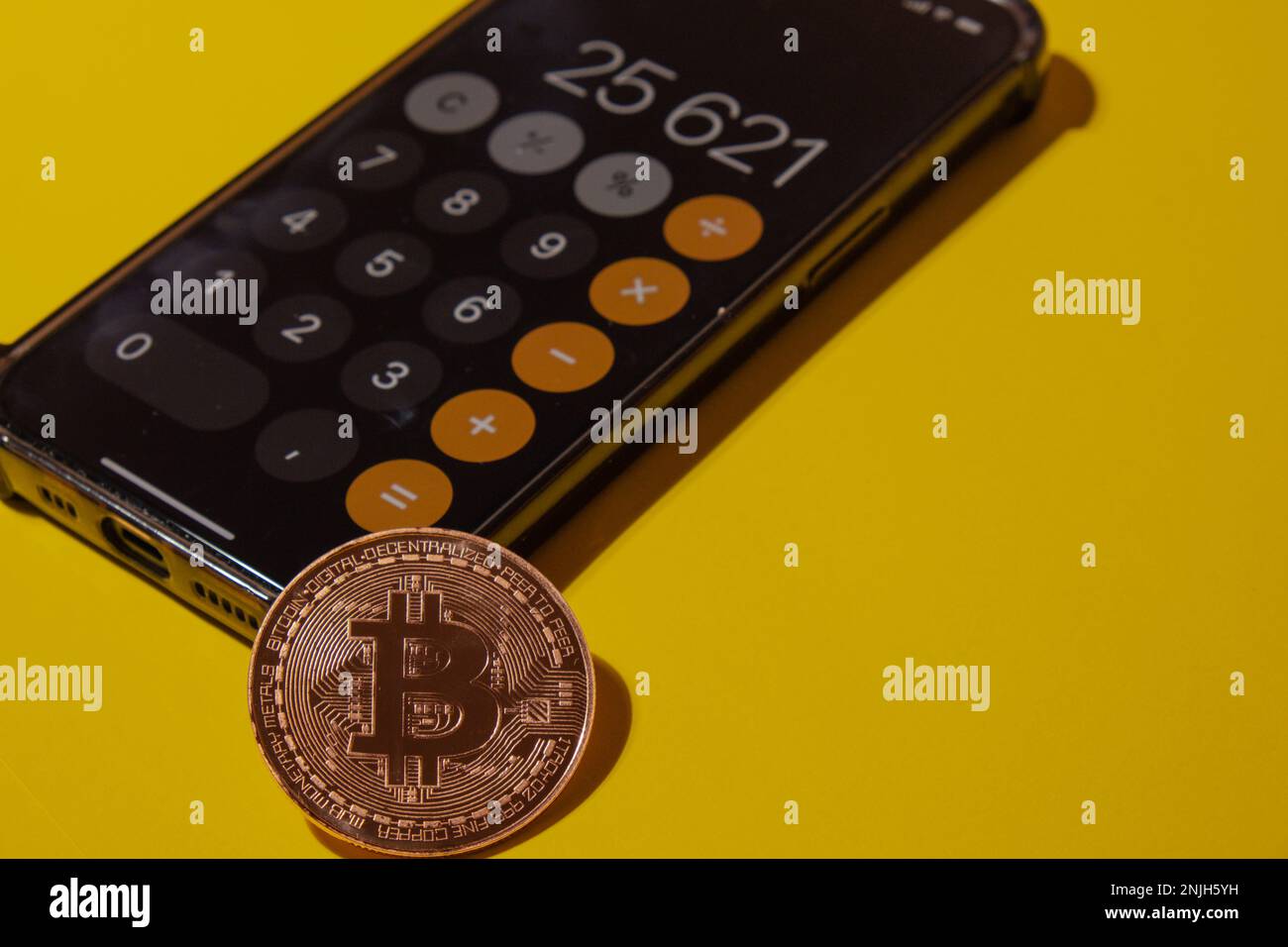 Gdansk, Poland - May 2022 Bitcoin gold coin on mobile phone with calculator on screen. Mining trading concept. BTC golden money. Worldwide virtual internet Cryptocurrency or crypto digital payment system. Digital coin money farm in digital cyberspace Stock Photo