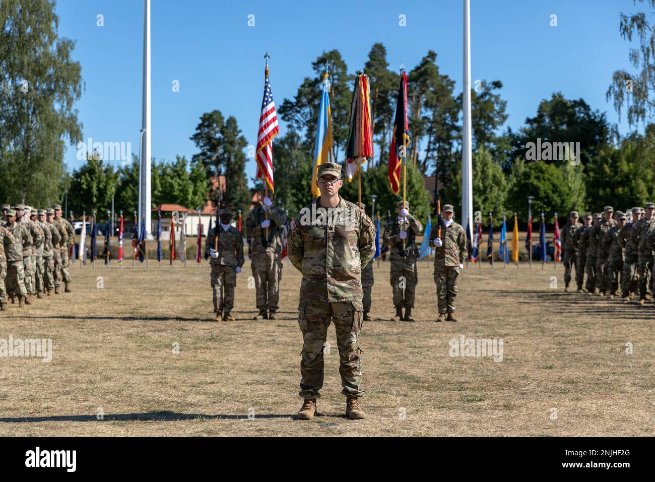 U.S. Army Lt. Col. Todd Hopkins, chief of staff of Task Force Gator, 53rd Infantry Brigade Combat Team, Florida Army National Guard stand in front of a color guard and formation of Soldiers from two task forces during the Joint Multinational Training Group-Ukraine Transfer of Authority ceremony in Grafenwoehr, Germany, August 8, 2022. Soldiers from Task Force Orion, 27th Infantry Brigade Combat Team, New York Army National Guard assumed the JMTG-U mission from Task Force Gator, and will ensure the combat effectiveness of Ukrainian military personnel training on systems and equipment issued und Stock Photo