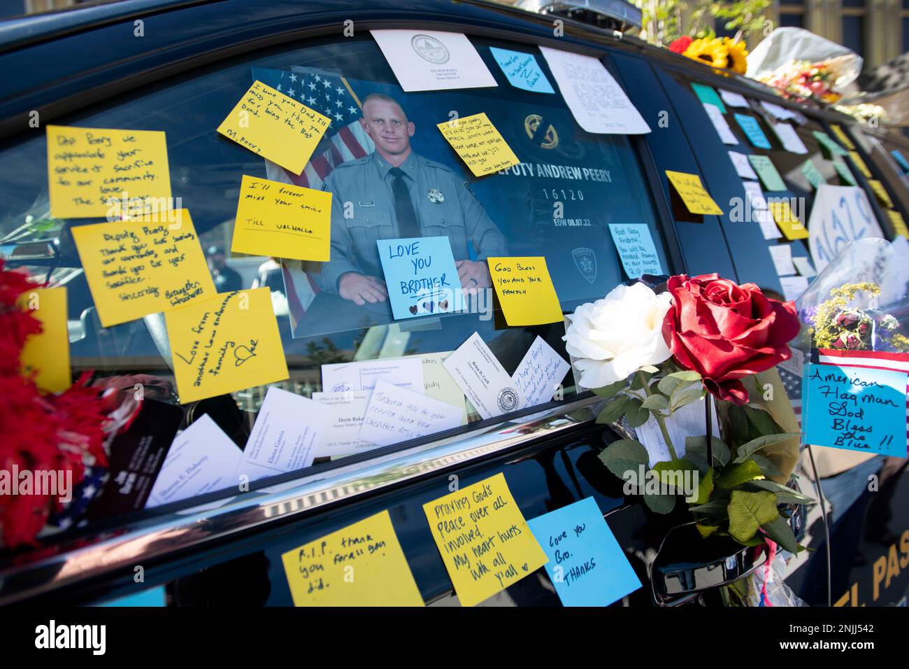 An El Paso County Sheriff's Office vehicle is covered with flowers and