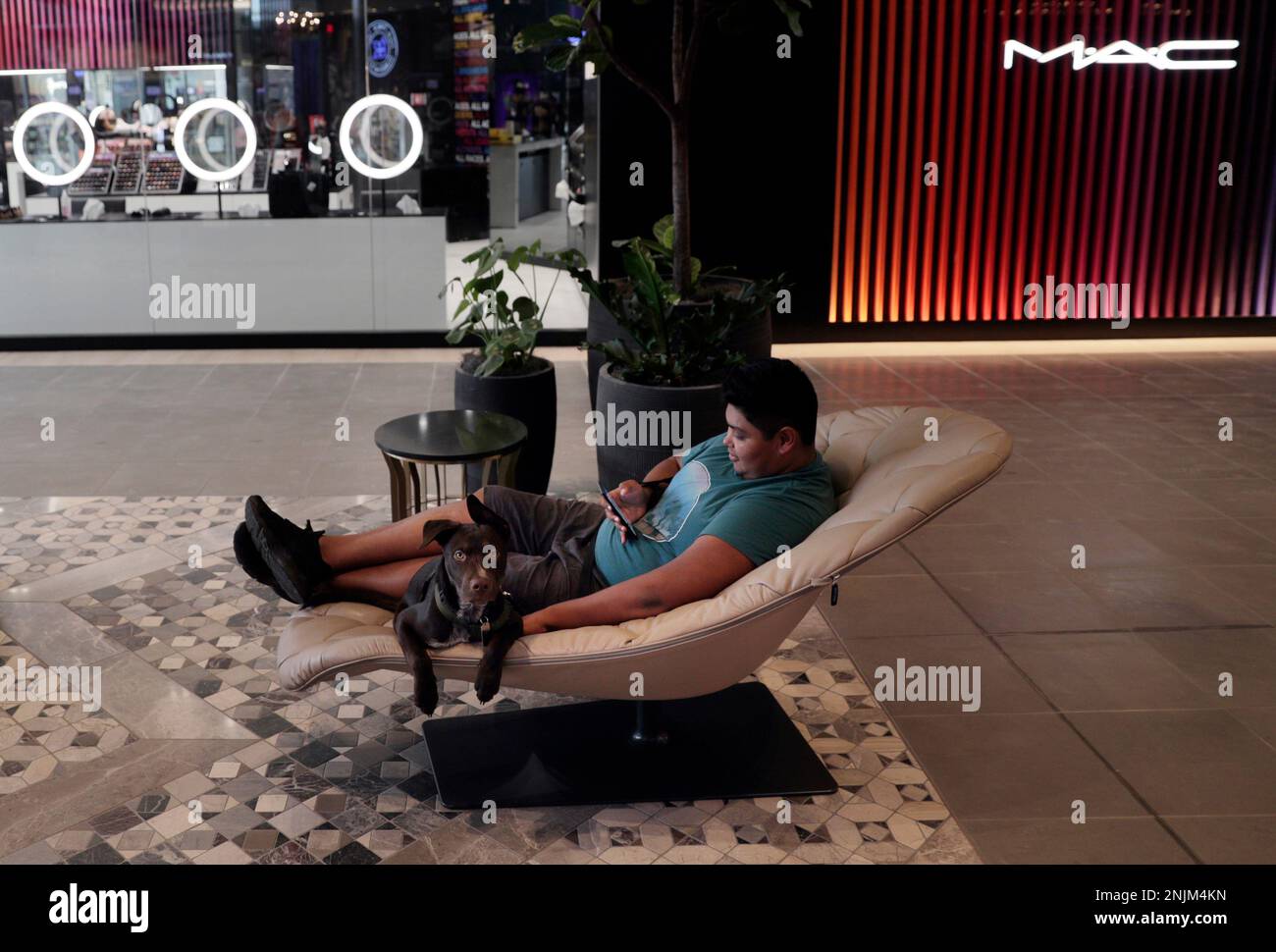 Angelo Cruz rests with his dog Simba inside the existing part of the