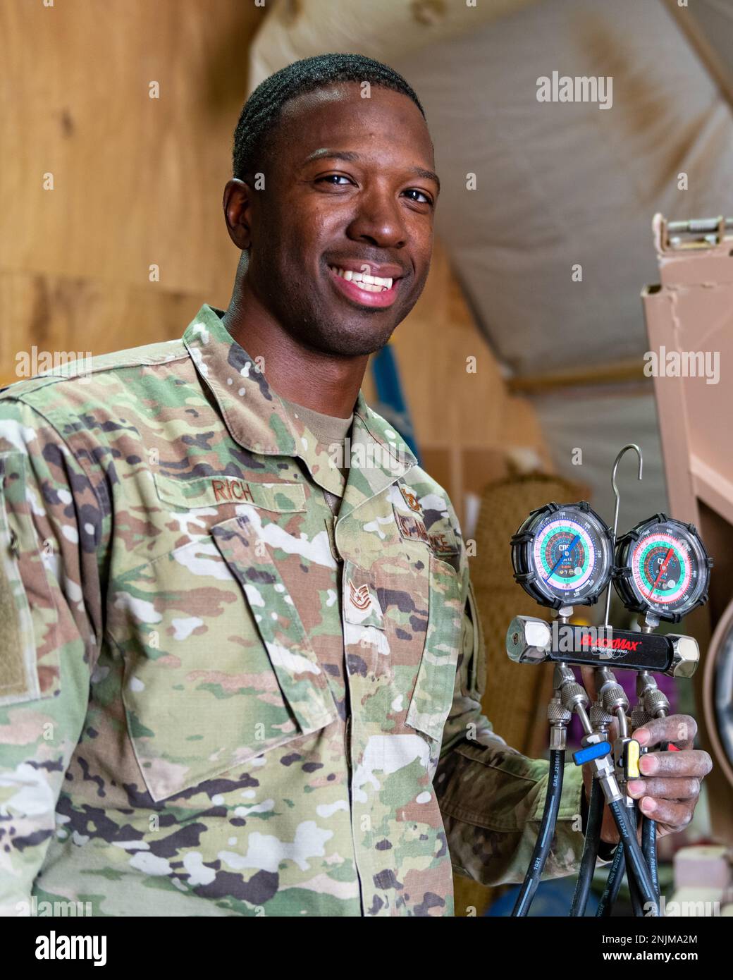 U.S. Air Force Tech. Sgt. Lawton Rich, a heating, ventilation, and air conditioning craftsman with the 378th Expeditionary Civil Engineer Squadron, poses with an HVAC unit pressure tester at Prince Sultan Air Base, Kingdom of Saudi Arabia, Aug. 9, 2022. Rich won the month of July’s Unsung Hero award, presented by the PSAB Top 3 Association, which recognizes up-and-coming leaders within the ranks of E5 and E6 who exemplify their service’s core values, inspire others and contribute to the improvement of customer service and the overall mission. Stock Photo