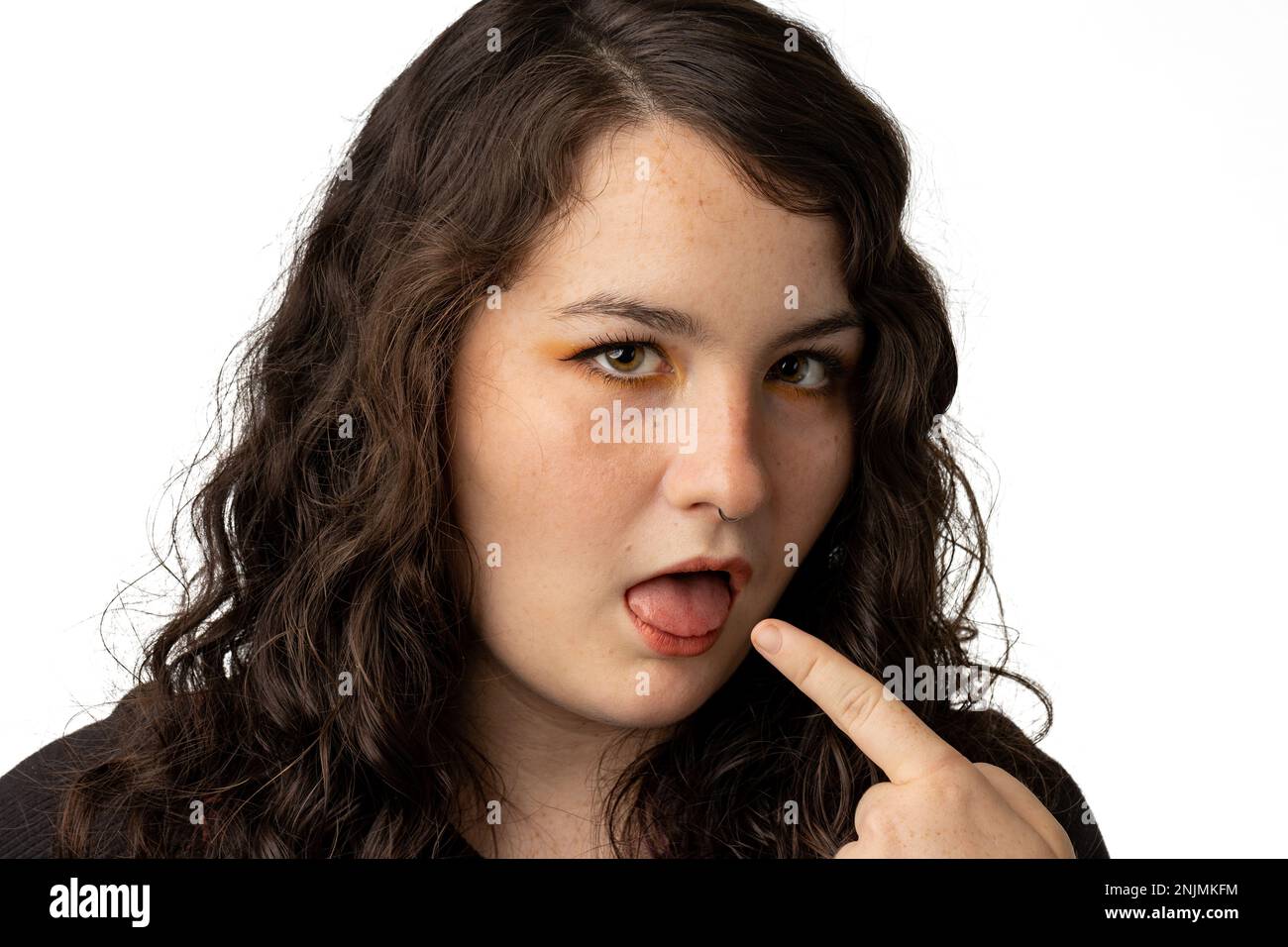 Close up of young woman making a face of disapproval, white background. Stock Photo