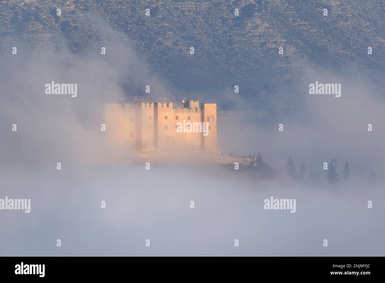 Mequinenza Castle between fog in a winter sunrise (Bajo Cinca, Zaragoza, Aragon, Spain) ESP: Castillo de Mequinenza entre la niebla en un amanecer Stock Photo