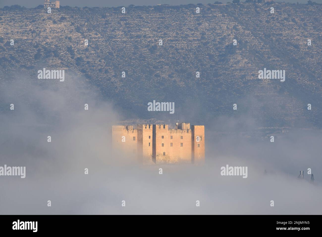 Mequinenza Castle between fog in a winter sunrise (Bajo Cinca, Zaragoza, Aragon, Spain) ESP: Castillo de Mequinenza entre la niebla en un amanecer Stock Photo