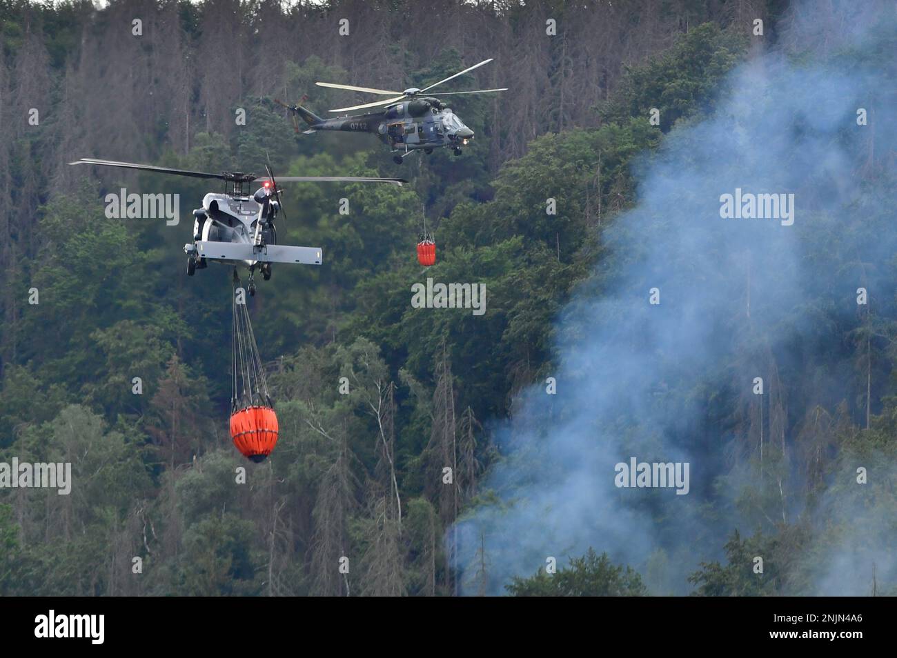 Helicopters carrying water to extinguish a wildfire in the area of the Ceske Svycarsko , Czech