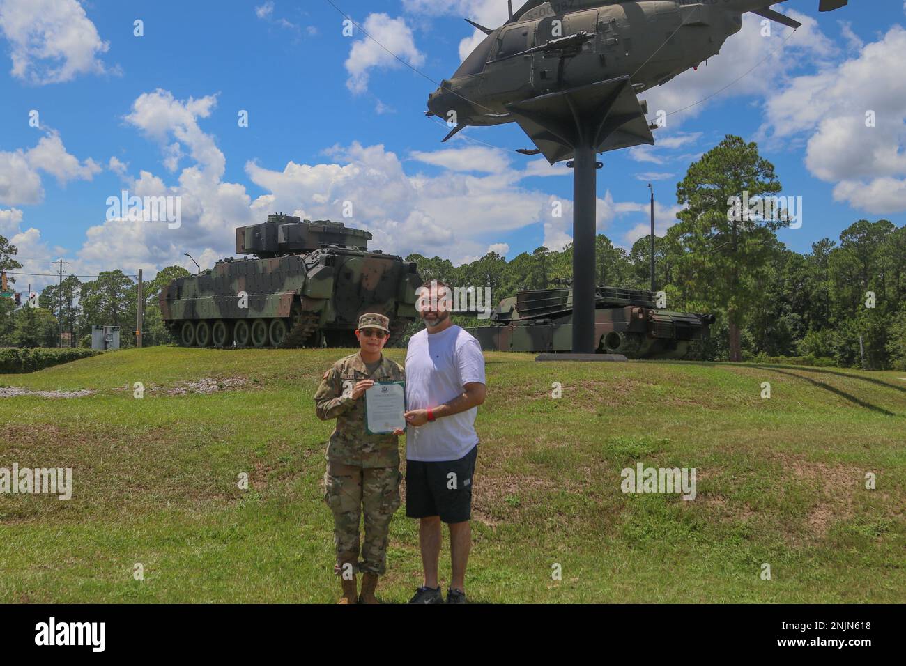 U.S. Army Sgt. Summer Keiser, a public affairs mass communications specialist assigned to 3rd Infantry Division, and Michael Touchet, manager of technical support and services for V-22 FMS Bell Helicopter in Camp Kisarazu, Tokyo, pose for a photo during a promotion ceremony at the main gate static display on Fort Stewart, Georgia, August 9, 2022. The static display holds an OH-58 Kiowa, one of thirty helicopters Keiser’s uncle, Touchet, oversaw in his time with 3rd Squadron, 17th Cavalry Regiment, 3rd Combat Aviation Brigade, 3rd ID, and Keiser chose the spot to honor his service and continue Stock Photo