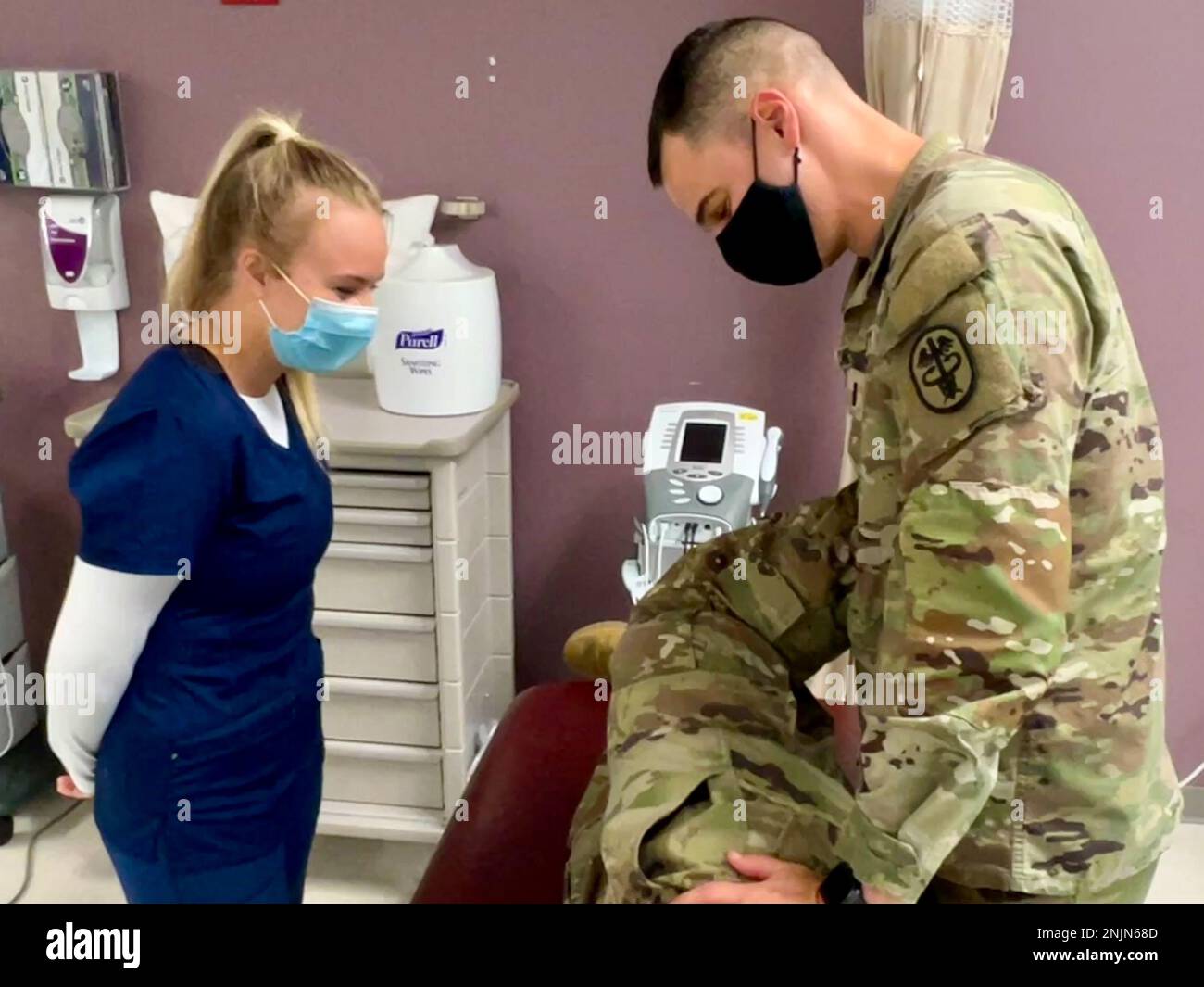 1st Lt. Steven Candeto demonstrates the Obers Test, which evaluates a tight, contracted or inflamed Tensor Fasciae Latae (TFL) and Iliotibial band (ITB) for Christina McDonald, a member of the Crimson Tide Reserve Officer Training Corps (ROTC) Battalion and a kinesiology major from the University of Alabama. McDonald spent two weeks shadowing the physical therapists as an American Red Cross volunteer for Bayne-Jones Army Community Hospital at the Joint Readiness Training Center and Fort Polk, Louisiana. Stock Photo