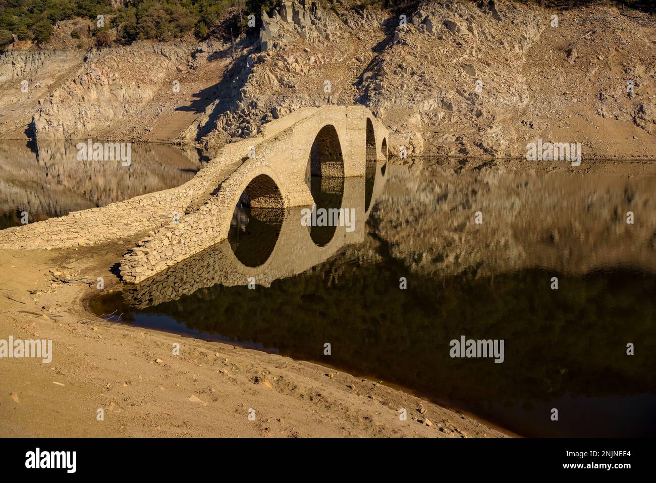 Querós medieval bridge, in the Susqueda reservoir, submerged after the construction of the reservoir and it can be seen in periods of strong drought Stock Photo