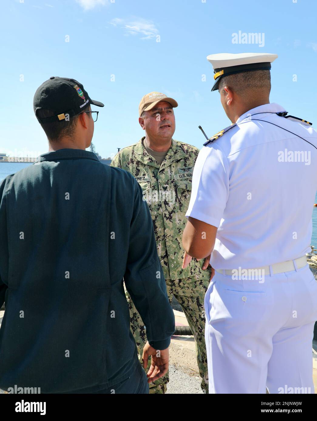 U.S. Navy Logistics Specialist 1st Class Luis Martinez, center, discusses an upcoming fuel delivery with Brazilian submarine crewmembers Nelson Luiz Moreira Da Silva Jr., right, and Gabriel Fontes Melo Bitencort. Stock Photo