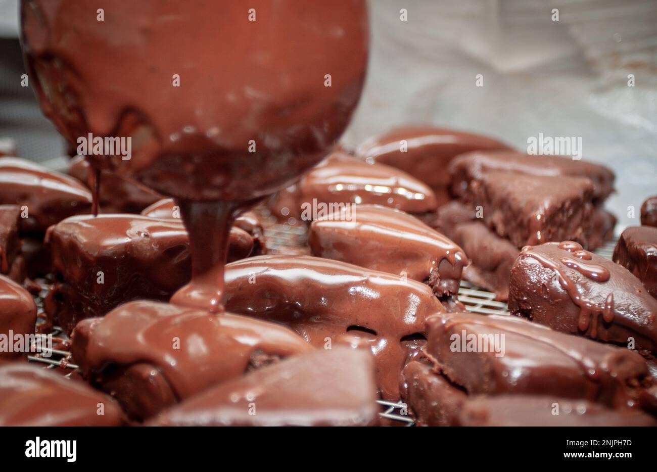 Pouring fudge on brownies for multiple servings Stock Photo